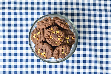 Top view of cookies with peanut and chocolate chips in glass bowl isolated on napkin background. Freshly Baked Homemade. perfect for bakery advertisements and dessert menus. Close up. Above.