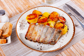 Delicious fried pork ribs served with side dish of baked potatoes. Hearty dinner.