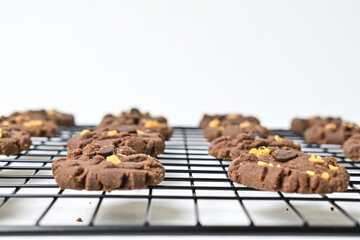 Side view of cookies with peanut and chocolate chips on the baking rack, isolated on white background. Freshly Baked Homemade. perfect for bakery advertisements and dessert menus. Selective focus.