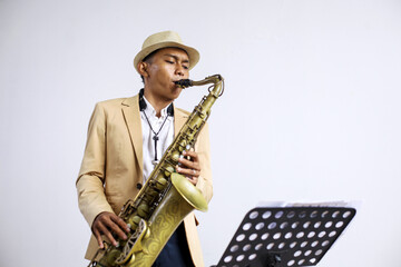 Fototapeta premium Saxophonist In Formal Suit Practicing Saxophone In Front Of Musical Stand At Home