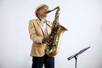 Fototapeta premium Young Musician Man In Formal Suit Playing Saxophone While Standing