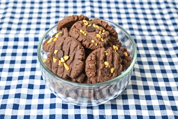 Close up view of cookies with peanut and chocolate chips in glass bowl isolated on napkin background. Freshly Baked Homemade. perfect for bakery advertisements and dessert menus.