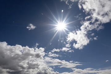 Radiant Sunlight Bursts Through Fluffy Clouds in a Stunning Deep Blue Sky