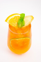 refreshing orange citrus cocktail with sliced lemon and mint leaves served in clear glass over ice on white background. High quality photo