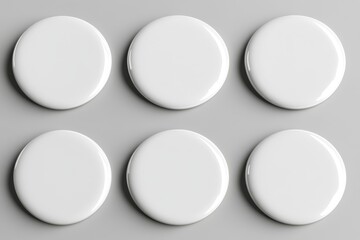Six blank white round badges on a gray surface