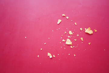 Snack crumbs scattered on a vibrant red background