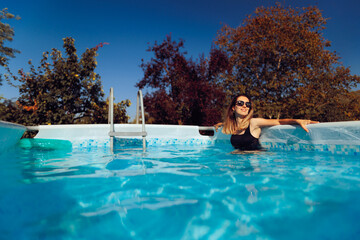 Happy Woman Enjoying Her Above the Ground Pool. Person relaxing at home in the swimming pool in...