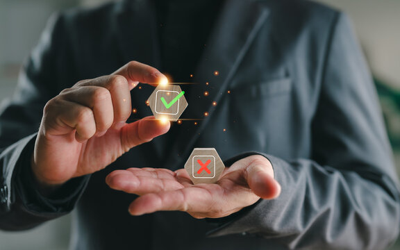 Businessman holding check mark and cross symbols representing decision making, risk assessment, correct vs incorrect choices, evaluation process, and business strategy concept.