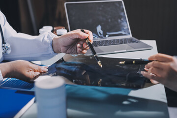 Male and female doctors are having a meeting in a hospital room.