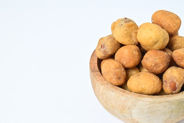 Photo of egg nuts in the little wooden bowl isolated on white background. Clipping path. Close up. Half view. Copy space, empty, free, negative.