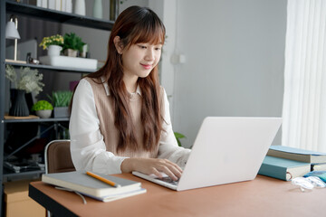 Asian woman working with laptop in living room
