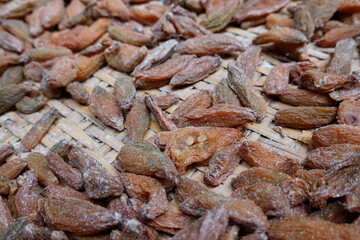 assortment of dried bilimbi fruits displayed on a traditional woven tray