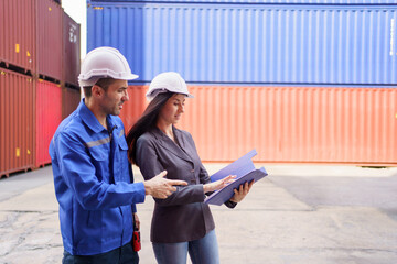 Fototapeta premium Businesswoman and logistic or shipyard engineer have a discussion or business due at container yard.