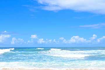 Beach and waves from side view. Blue and turquoise water color background. Summer seascape. Travel concept and idea. Blue sky with clouds. Sea.