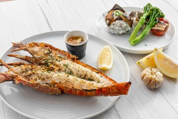 Succulent grilled lobster tail served with zesty lemon, garlic, and dipping sauce alongside...