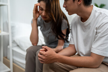 Fototapeta premium Asian husband comforting his wife crying with tears for life problem. 