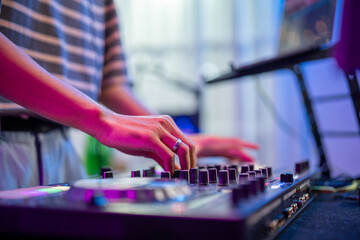 Close up of man artist DJ mixing and scratching music mixer controller.