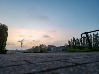 This is a peaceful and picturesque view that showcases a wind turbine set against a tranquil...