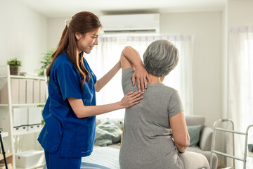 Obraz premium Elderly Asian woman receive physical therapy with support of caregiver. 