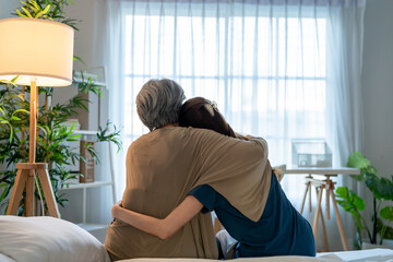Rear view of elderly mother comfort upset daughter crying for problem. 