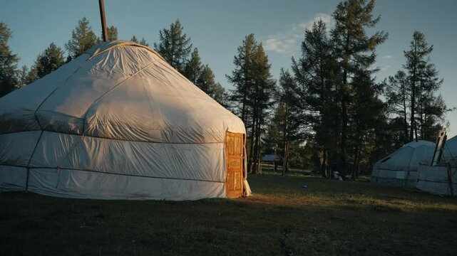 Mongolian ger at sunrise in the Altai mountains, with soft morning light casting shadows on the rugged terrain in Mongolia, Asia