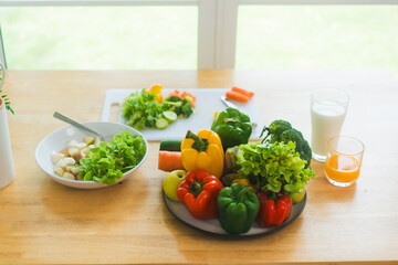 A fresh assortment of colorful vegetables, orange juice,milk highlights a balanced diet.The measuring tape symbolizes healthy eating,weight control,nutrition-focused lifestyle choices for wellness