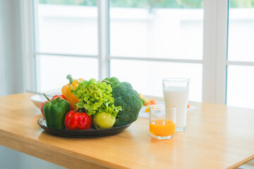 A fresh assortment of colorful vegetables, orange juice,milk highlights a balanced diet.The measuring tape symbolizes healthy eating,weight control,nutrition-focused lifestyle choices for wellness