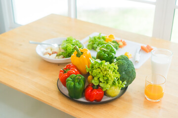 A fresh assortment of colorful vegetables, orange juice,milk highlights a balanced diet.The measuring tape symbolizes healthy eating,weight control,nutrition-focused lifestyle choices for wellness