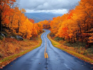 Fototapeta premium Winding road through vibrant autumn foliage, leading to misty mountains