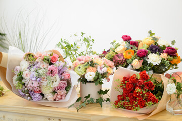 Bouquet and flower basket on wooden table

