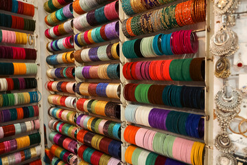 Rows of colorful, ornate Indian bangles displayed on metal racks. traditional jewelry in Kerala India. Kerala Indian Indian girl wearing gold jewellery old fashion. Ethnic ornaments of India