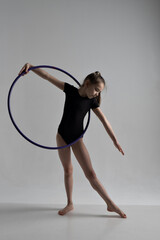 A girl in a swimsuit and a dress shows beautiful athletic elements on a white background. Ballet, rhythmic gymnastics, fabric, aesthetics, grace