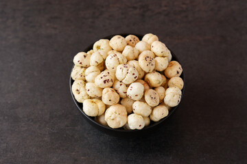Bowl with puffed Lotus seed. Indian Organic Makhane Makhana puffed lotus seed or Fox nuts. Flavoured Prickly Water Lily. Edible seeds popular in India