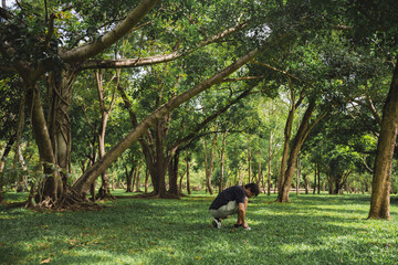 wellness concept with asian man exercise with tree in park on summer season