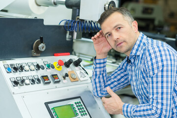 Obraz premium asian machine operator in production plant checking data