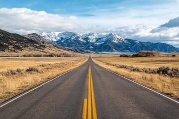 Fototapeta premium Empty road leading to snow-capped mountains
