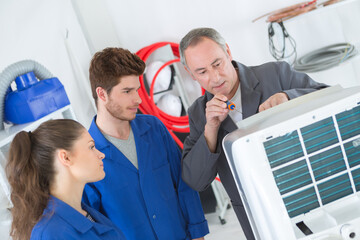 Obraz premium apprentices learning to repair industrial air conditioning