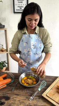 Pastry chef adding panela with a spoon while preparing carrot cake