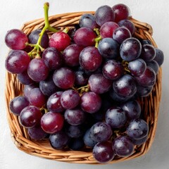 Fototapeta premium Grapes in a Basket: A vibrant display of ripe, juicy grapes arranged in a rustic wicker basket, showcasing their rich color and texture, a symbol of nature's bounty.