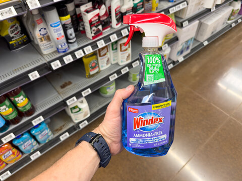 Hand Holding Bottle of Windex Ammonia Free Glass Cleaner in Store Aisle

