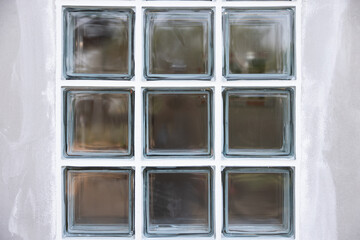 Close up transparent clear glass block on concrete wall under construction. To apply sealant at groove edge around border glass block. Construction material for light go inside room.