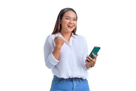 Excited young Asian woman using mobile phone gesturing yes with raised fist reacting to online news isolated on transparent background