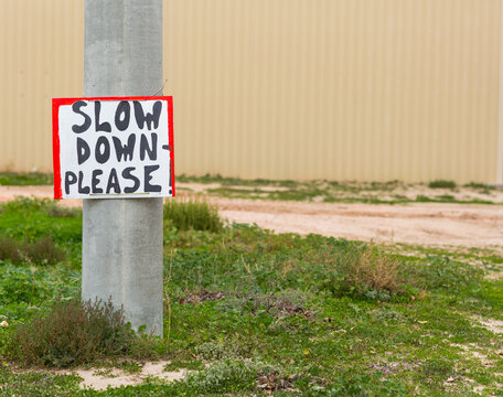 Handprinted sign slow down please