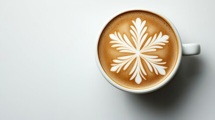 A frothy cappuccino adorned with intricate latte art sits on a crisp white surface, its creamy, star shaped design promising a warm and inviting coffee experience.