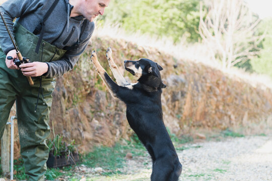 dog jumping up to a fisherman