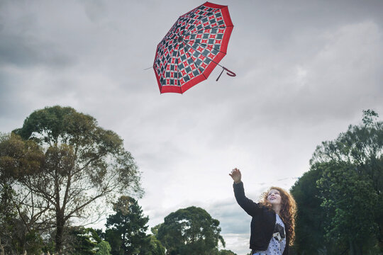 Young girl losing her umbrella on a windy winter day