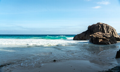 Huge dangerous waves crashing on the beautiful Seychelles beach, with powerful ocean surf