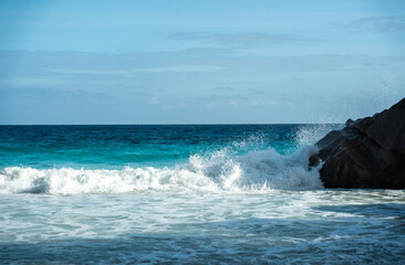 Huge dangerous waves crashing on the beautiful Seychelles beach, with powerful ocean surf