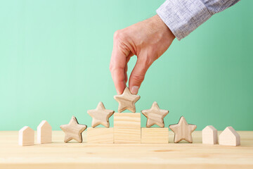 Hand picking small house and five star concept. Idea of high rating and service