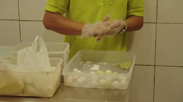Preparing a warm bowl of ginger ronde in Bandung. Ronde is a traditional Peranakan dessert popular in Bandung, Indonesia, made with glutinous rice balls served in sweet ginger broth.